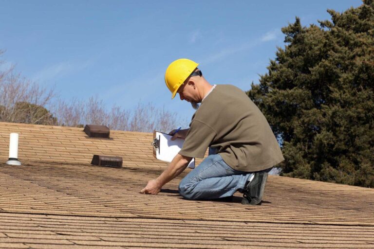 Certified roof inspector looking at possible shingle damage.